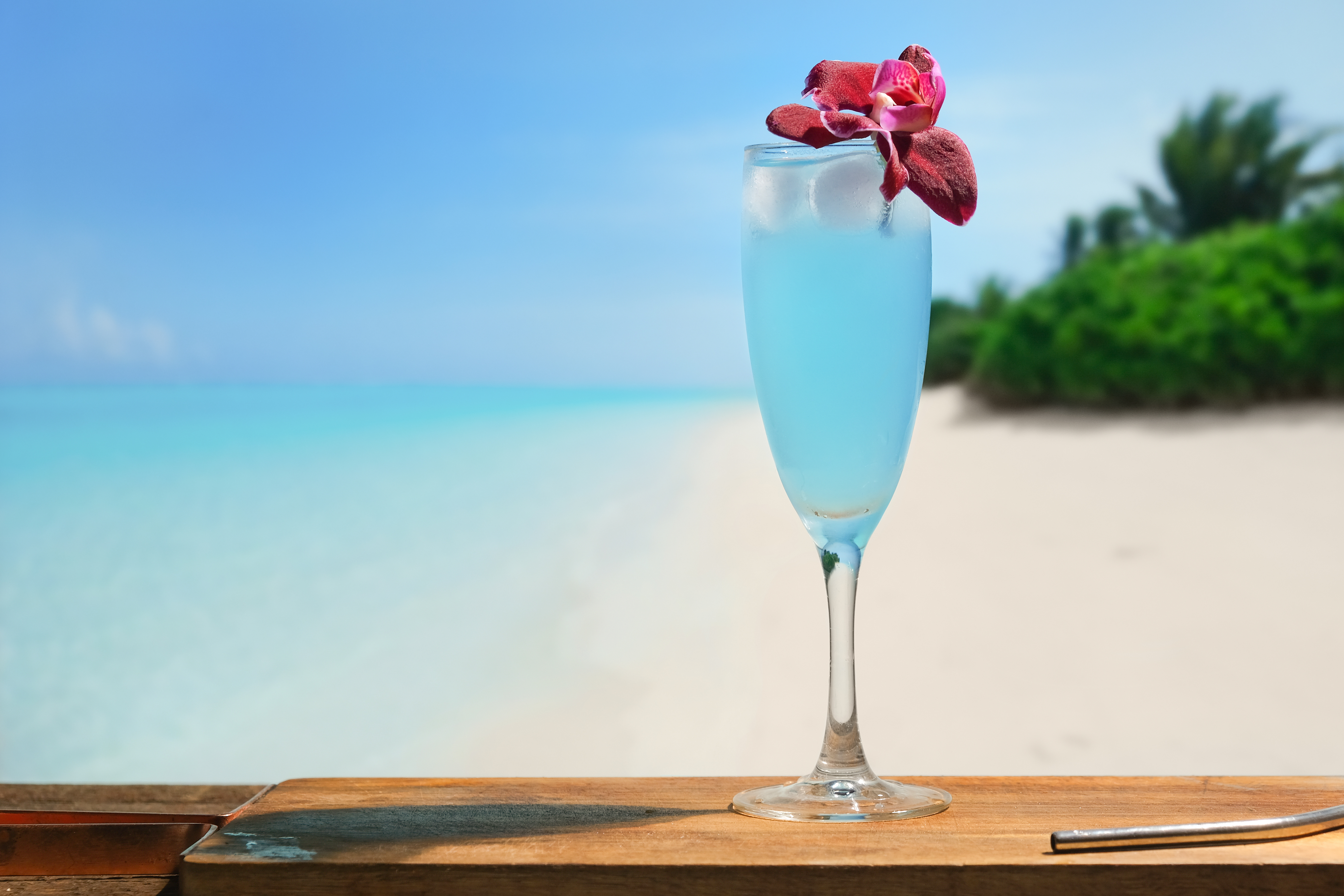 Summer alcoholic cocktail Blue Lagoon in bar on tropical beach.